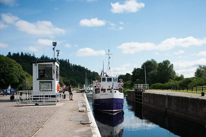 Boat named Jacobite Queen docked at a canal lock near a small building